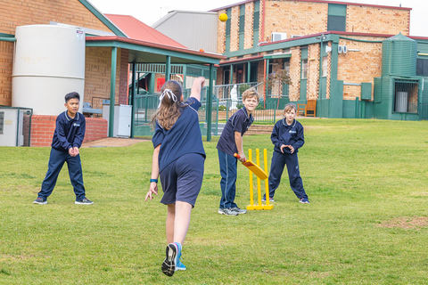 Students playing cricket